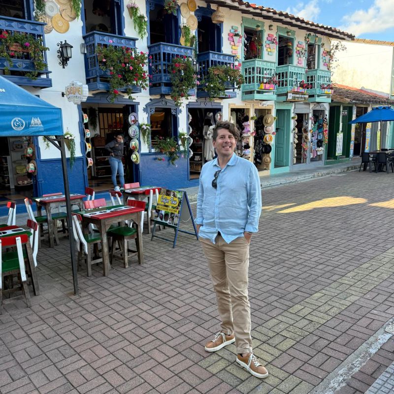 Standing on a cobblestone street lined with colorful balconies in Colombia